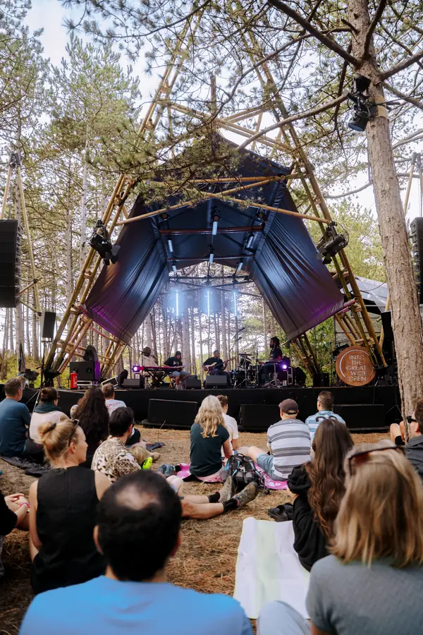 Het bamboe podium in het bos op Vlieland, met publiek ervoor